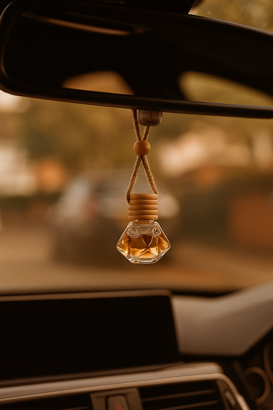 Car air freshener hanging from a car's rearview mirror with a blurred road background